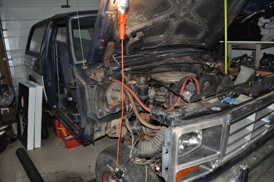 1986 Ford Bronco engine bay with hood open, showing engine and front grille