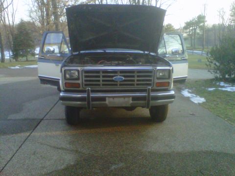 1986 Ford Bronco - Front view of a 1986 Ford Bronco with the hood and driver's side door open.
