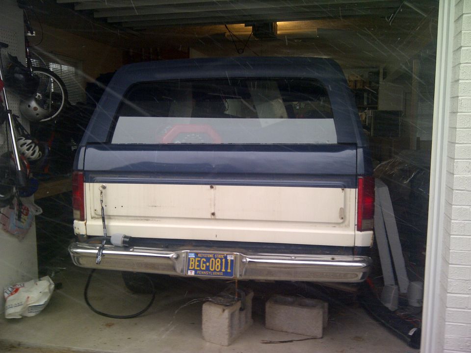 Two-tone white and blue SUV rear view, parked in garage