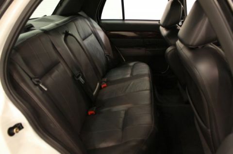 2004 Mercury Grand Marquis - The interior of a car, showing the rear seats and part of the front seats with black leather upholstery.