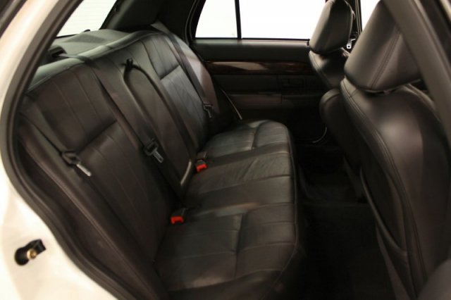 Back seat and part of the front seats of a car. Black leather upholstery