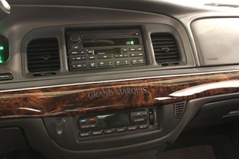 2004 Mercury Grand Marquis - The interior dashboard features wood grain trim with the 'Grand Marquis' nameplate visible.