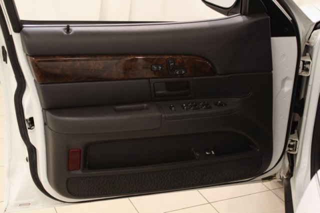 Interior door panel of a 2004 Mercury Grand Marquis with wood trim and power controls
