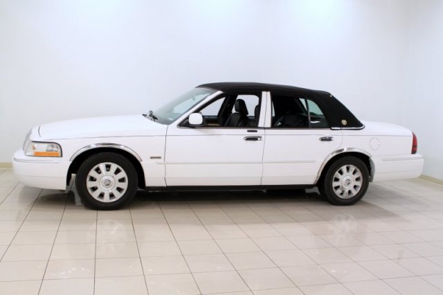 White Mercury Grand Marquis with a black vinyl top, seen from the side