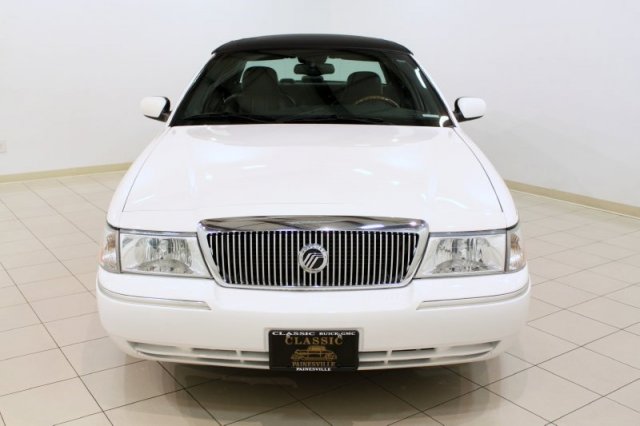 White Mercury Grand Marquis with a chrome grille and black vinyl roof, front view