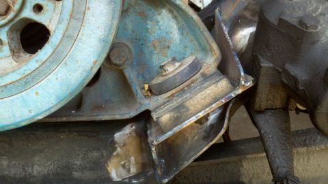 1993 Ford F-350 - Close-up of a custom-welded engine mount bracket, indicating modifications to the engine assembly.