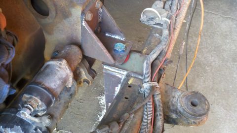 1993 Ford F-350 - Close-up view of a custom-welded engine mount bracket, showing wiring and mechanical components.