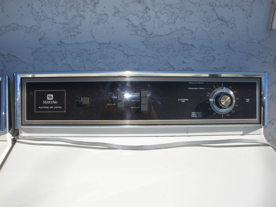 Maytag dryer control panel with chrome trim, black face, and dial timer