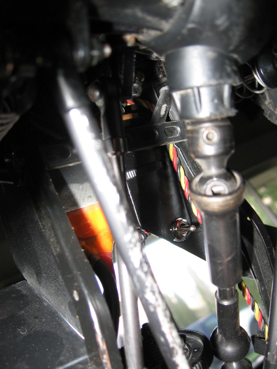 RC car chassis with drive shafts, suspension components, and wiring visible