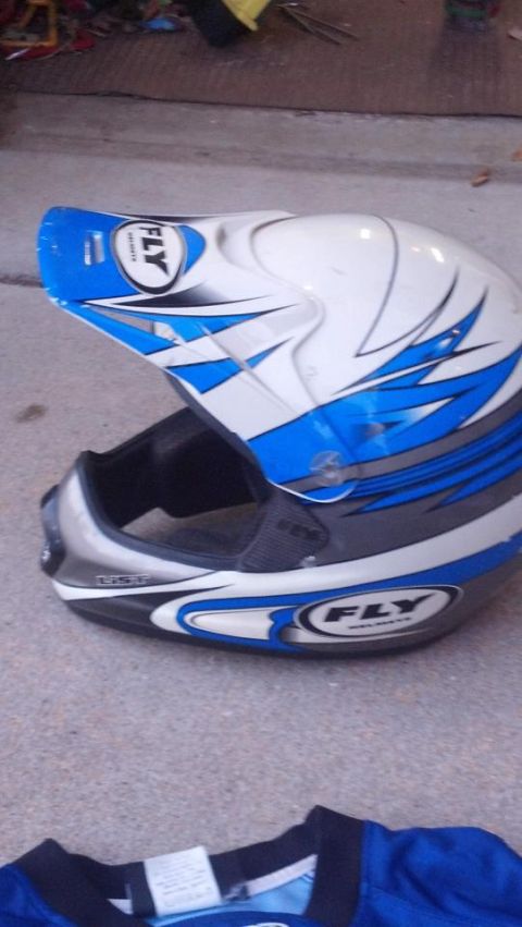 2000 Mercury Grand Marquis - A white and blue FLY motocross helmet rests on a concrete surface next to a blue shirt.