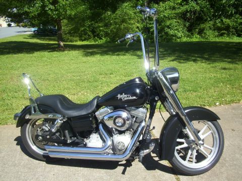 2009 Harley-Davidson Super Glide - Black 2009 Harley-Davidson Super Glide motorcycle with ape handlebars parked on pavement.