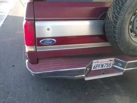 1991 Ford Bronco - Rear view of a maroon Ford Bronco showing its spare tire and chrome bumper.