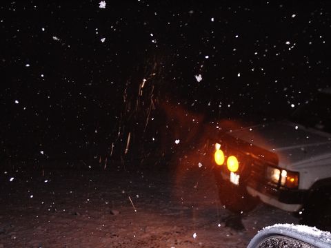 1996 Ford Bronco - A white SUV's headlights illuminate the falling snow during a winter storm.