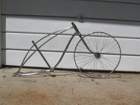 1994 Ford Bronco - A bare bicycle frame with a single wheel leans against a garage door.