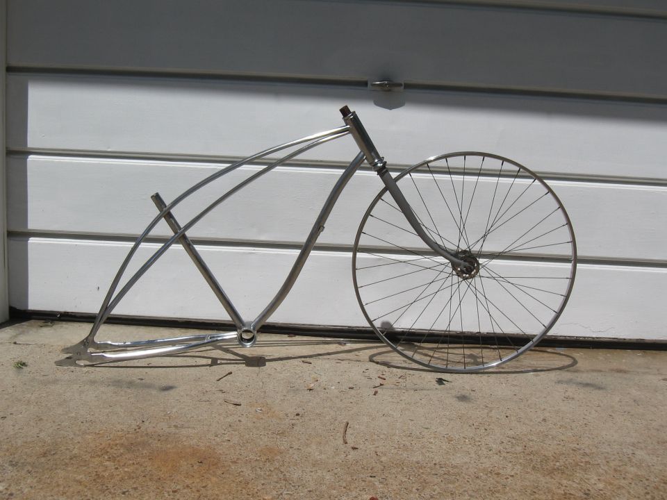 Chrome bicycle frame with one large spoked wheel in front