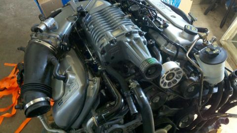 2004 Ford Crown Victoria - Close-up view of a supercharged V8 engine assembly, showing intricate mechanical components and plumbing.