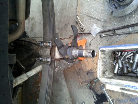 1978 Ford Bronco - A close-up view of a vehicle's front axle spindle and brake assembly, with tools nearby.