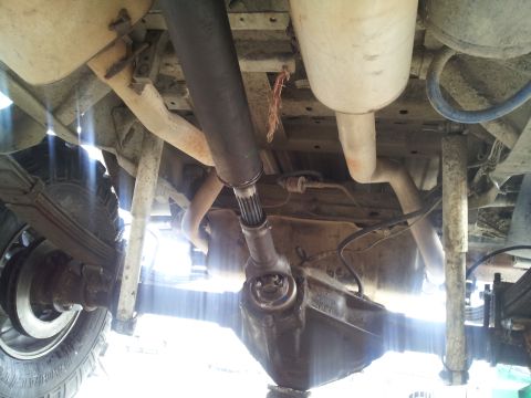 1978 Ford Bronco - The underside of a vehicle reveals its mechanical components, including the drivetrain and suspension.