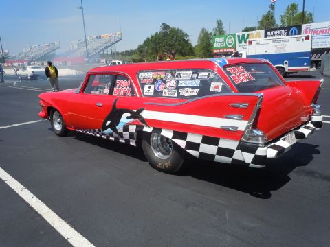 1982 Chevrolet Camaro - A red station wagon with racing decals and graphics is on the drag strip, with spectators and other vehicles in the background.