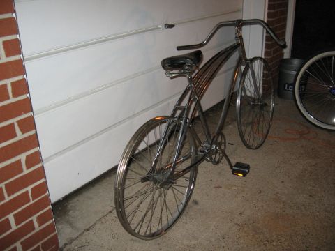 1994 Ford Bronco - A vintage bicycle with chrome frame and spokes sits in front of a white garage door.