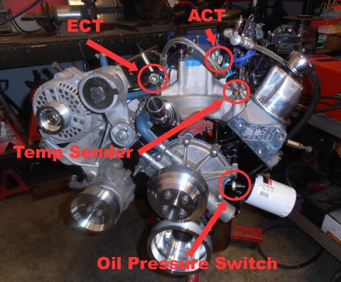 1990 Ford Bronco - Front view of a freshly assembled V8 on an engine stand in a shop, annotated with red circles and arrows labeling the ECT and ACT sensor bu…