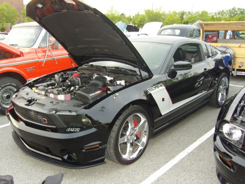 2007 Ford Mustang - A black 2007 Ford Mustang is displayed with its hood open, revealing the engine and a prominent "042" badge on the front fender.