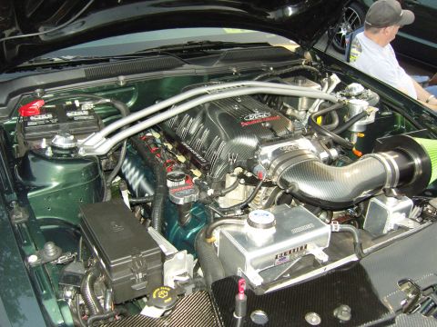 2007 Ford Mustang - Close-up of a modified Ford V8 engine, a prominent supercharger and carbon fiber intake components.