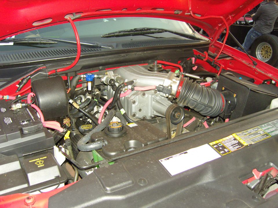 Engine bay with supercharger and red wiring