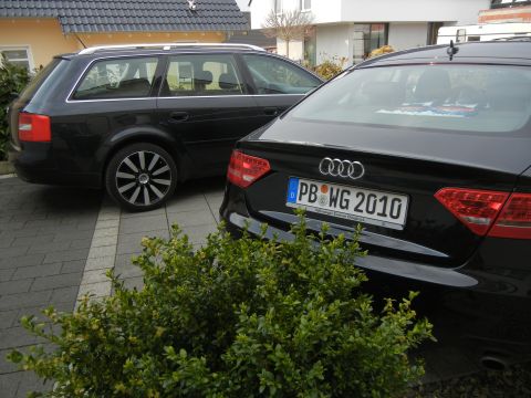 2010 Audi A4 - Two black Audi cars are parked side-by-side in a driveway.