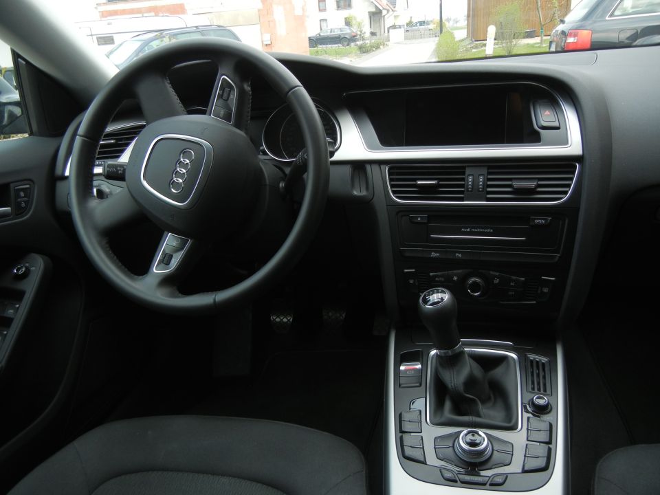 2010 Audi A4 interior showing steering wheel, dashboard, and center console with manual shifter