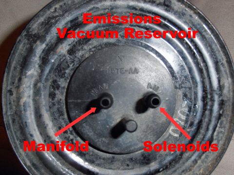 1990 Ford Bronco - Face-on shot of a round steel emissions vacuum reservoir canister stamped D5TE-AA, with three black nipple ports marked MAN and AMP. Red ov…