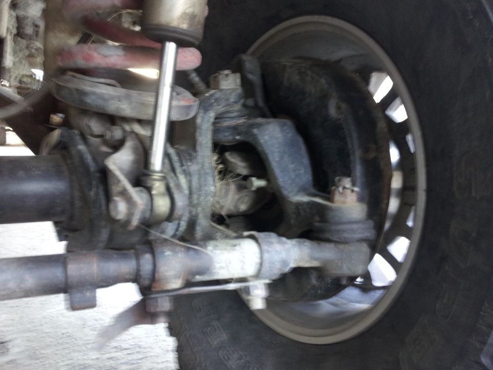 Close-up of front suspension and steering linkage with coil spring and shock absorber