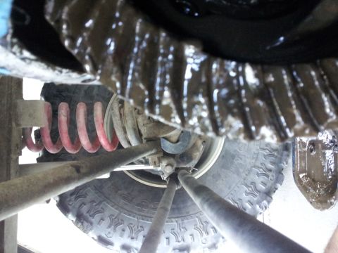 1978 Ford Bronco - Close-up of vehicle differential and suspension parts, including a coil spring and tire.