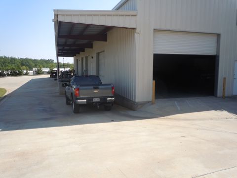 1980 Pontiac Trans Am - A gray pickup truck is parked in front of a warehouse with its rear facing the camera.