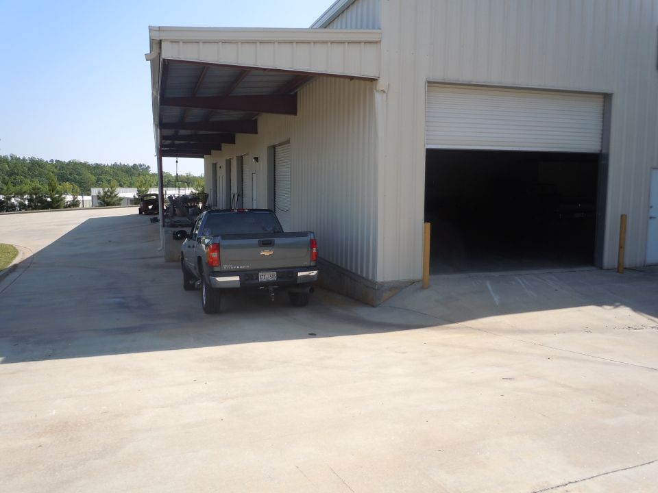 Gray pickup truck's rear view parked by warehouse