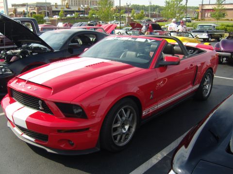 2007 Ford Mustang - A red 2007 Ford Mustang Shelby GT500 convertible is parked at a car show.