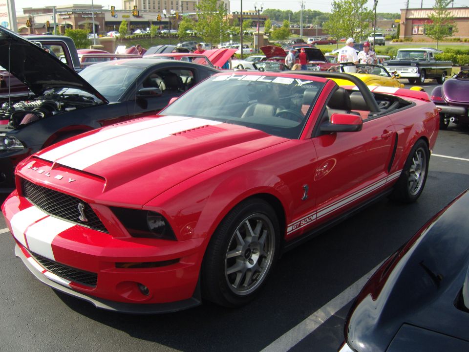 Red convertible 2007 Ford Mustang Shelby GT500 with white racing stripes