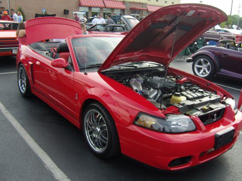 2007 Ford Mustang - Red convertible parked at a car show, hood and trunk open to display the engine and interior.