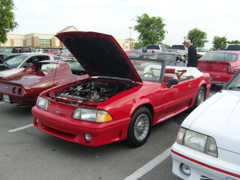 2007 Ford Mustang - A red 1987 Ford Mustang GT convertible is displayed with its hood open, parked alongside other vehicles at a car show.
