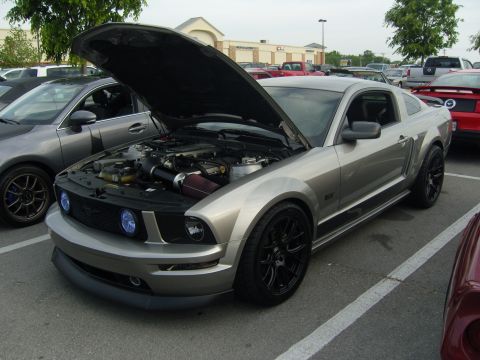 2007 Ford Mustang - Silver 2007 Ford Mustang GT parked at a car meet, hood raised to show the engine.