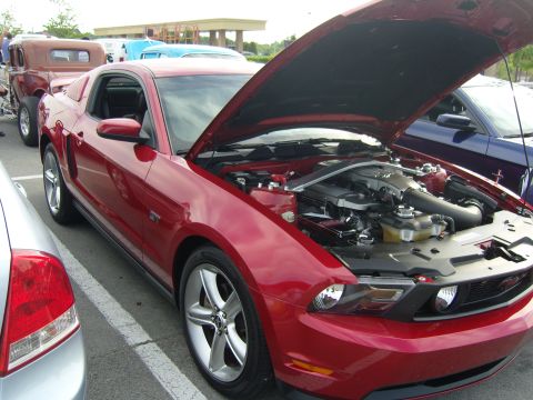 2007 Ford Mustang - A red Ford Mustang is parked with its hood open, revealing the engine compartment.