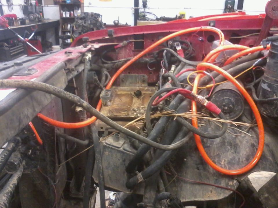 Engine bay with dual battery tray and isolator, orange cables and various hoses