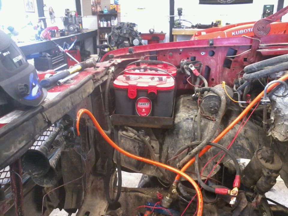 Dual Optima batteries installed in an engine bay with wiring and hoses visible