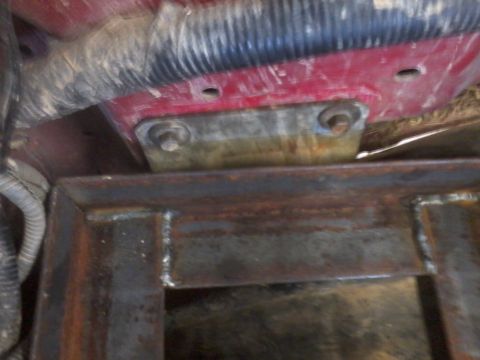 1995 Ford F-150 - Close-up of a dual battery tray with an isolator, mounted to a red surface.