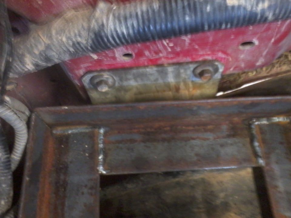 Dual battery tray with isolator mounted to red metal surface