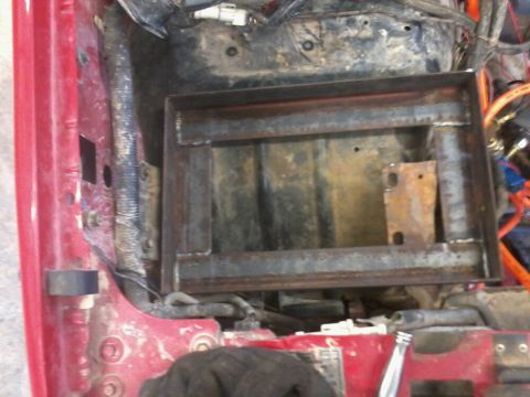 1995 Ford F-150 - A metal bracket, likely for a battery tray, shows signs of rust and wear in the engine compartment.