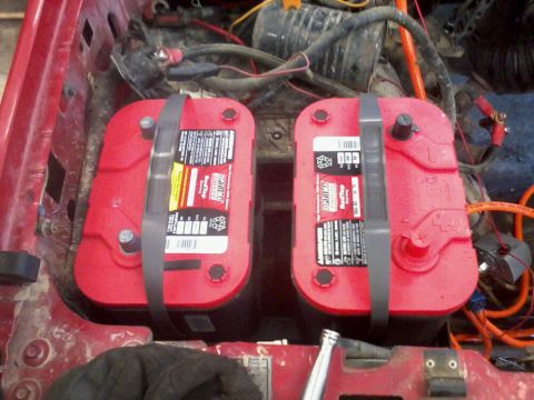 1995 Ford F-150 - Dual battery setup with an isolator is visible in the engine compartment of a red vehicle.