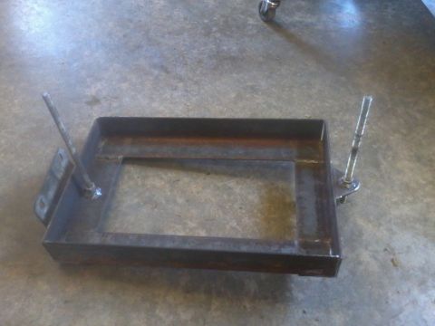 1995 Ford F-150 - A metal dual battery tray with an isolator is shown on a concrete floor.