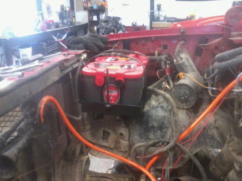 1995 Ford F-150 - A close-up view of a dual battery installation, Optima batteries and prominent orange wiring within an engine compartment.