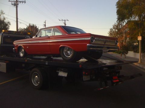 1964 Ford Ranchero - Red 1964 Ford Falcon coupe being towed on a flatbed truck.